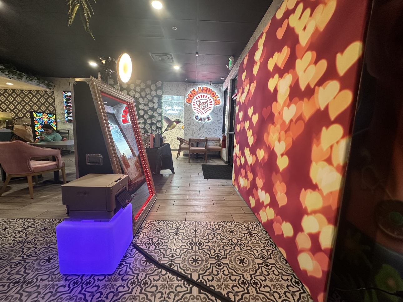 Mirror photo booth at a café with a glowing heart backdrop
